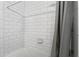 Close up view of the tiled shower and tub featuring white subway tiles and modern fixtures at 5107 W Platt St, Tampa, FL 33609