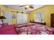 Bright bedroom with vibrant yellow walls, a ceiling fan, and a barn-style closet door at 5501 Highland S St, St Petersburg, FL 33705