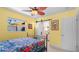 Bright bedroom featuring a metal bed frame, floral bedding, and a unique sliding barn door to the ensuite bathroom at 5501 Highland S St, St Petersburg, FL 33705