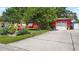 Exterior front view of red home with mature landscaping and a concrete driveway at 5501 Highland S St, St Petersburg, FL 33705