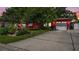 Charming red home featuring a well-manicured lawn and spacious driveway leading to an attached two-car garage at 5501 Highland S St, St Petersburg, FL 33705