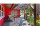 Outdoor seating on covered porch with patterned shade and landscaped surroundings at 5501 Highland S St, St Petersburg, FL 33705