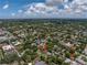 Wide aerial view of a residential area boasting mature trees and a mix of architectural styles under a partly cloudy sky at 635 Bay Ne St, St Petersburg, FL 33701
