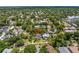 A close aerial of a well-kept two story home with landscaped lawns surrounded by mature trees in a suburban setting at 635 Bay Ne St, St Petersburg, FL 33701