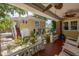 Inviting covered porch with brick pillars, wooden floors, ceiling fans, and exterior stairs to upper deck at 635 Bay Ne St, St Petersburg, FL 33701