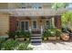 Cozy back porch with brick pillars, ceiling fans, rocking chairs, and lush plants in decorative planters at 635 Bay Ne St, St Petersburg, FL 33701