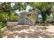Exterior view of a yellow two-story house with a brick driveway, stairs, and lush greenery at 635 Bay Ne St, St Petersburg, FL 33701
