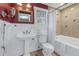 Charming bathroom featuring a pedestal sink, decorative mirror, and bathtub with tile surround at 635 Bay Ne St, St Petersburg, FL 33701