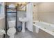 Well-appointed bathroom with a soaking tub, pedestal sink, and tiled walls, ideal for relaxation at 635 Bay Ne St, St Petersburg, FL 33701