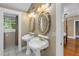 Charming bathroom featuring dual pedestal sinks, vintage mirrors, and stylish lighting fixtures at 635 Bay Ne St, St Petersburg, FL 33701