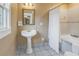 Bathroom with a pedestal sink, tub, and neutral tile, designed for comfort and convenience at 635 Bay Ne St, St Petersburg, FL 33701