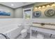 Bright bathroom featuring a double vanity, bathtub, and white wainscoting at 635 Bay Ne St, St Petersburg, FL 33701