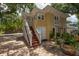 Charming yellow home with stairs to upper entrance and brick-paved backyard at 635 Bay Ne St, St Petersburg, FL 33701