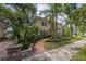 Charming yellow two-story home with lush landscaping, brick path, and a patterned driveway at 635 Bay Ne St, St Petersburg, FL 33701