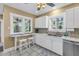 Bright eat-in kitchen featuring white cabinetry, stainless steel dishwasher, and tiled floors at 635 Bay Ne St, St Petersburg, FL 33701