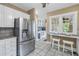 The kitchen features stainless steel refrigerator, white cabinets and bar seating by the window at 635 Bay Ne St, St Petersburg, FL 33701