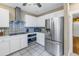 The kitchen features stainless steel appliances, white cabinets and tile backsplash at 635 Bay Ne St, St Petersburg, FL 33701