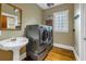 Laundry room with stacked washer and dryer, hardwood floors, and a pedestal sink at 635 Bay Ne St, St Petersburg, FL 33701