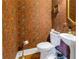 Quaint powder room with floral wallpaper, pedestal sink, and gold accents at 635 Bay Ne St, St Petersburg, FL 33701