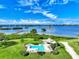 Aerial view of the community pool area with a Tiki hut and tropical landscaping with water views under blue skies at 780 Sarabay Rd # 16, Osprey, FL 34229