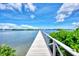 Waterfront property features a private dock with a beautiful scenic view under blue skies and scattered white clouds at 780 Sarabay Rd # 16, Osprey, FL 34229