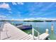 Waterfront property features a private boat dock with a boat and stunning blue skies and clear water views at 780 Sarabay Rd # 16, Osprey, FL 34229