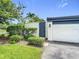 Exterior of the home showing garage door and lush landscaping on a bright, sunny day at 780 Sarabay Rd # 16, Osprey, FL 34229
