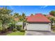 Beautiful home featuring a vibrant red tile roof, white garage door, and lush landscaping at 780 Sarabay Rd # 16, Osprey, FL 34229