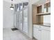 Bright and airy foyer with white tile flooring, shuttered doors, and a built-in bar area at 780 Sarabay Rd # 16, Osprey, FL 34229