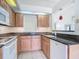 Kitchen featuring wood cabinets, granite countertops, tile flooring, and updated white appliances at 780 Sarabay Rd # 16, Osprey, FL 34229