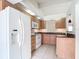 Well-lit kitchen with wood cabinets, granite countertops, and modern white appliances including a refrigerator at 780 Sarabay Rd # 16, Osprey, FL 34229