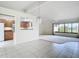Open-concept living room with a large window offering a view, tiled floors, and an adjacent kitchen area at 780 Sarabay Rd # 16, Osprey, FL 34229