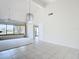 Spacious living room with high ceilings, large windows, tile flooring, and access to other rooms in the home at 780 Sarabay Rd # 16, Osprey, FL 34229