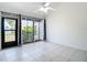 Sunlit living room features large tile flooring, ceiling fan, glass doors opening to the outside at 780 Sarabay Rd # 16, Osprey, FL 34229