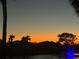Calming evening scene of a pond with a fountain silhouetted against the colorful twilight sky at 780 Sarabay Rd # 16, Osprey, FL 34229