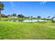 Beautiful pond with fountain surrounded by green grass and lush landscaping on a sunny day at 780 Sarabay Rd # 16, Osprey, FL 34229