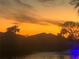 Tranquil evening view of a pond with a fountain reflecting the vibrant sunset sky at 780 Sarabay Rd # 16, Osprey, FL 34229