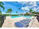 Resort-style community pool with multiple lounge chairs and tropical landscaping surrounded by a secure fence at 780 Sarabay Rd # 16, Osprey, FL 34229
