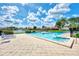 Community pool with lounge chairs and a view of the surrounding neighborhood and pond under a bright sky at 780 Sarabay Rd # 16, Osprey, FL 34229
