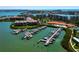Aerial view showcases a community marina, lush foliage, a pool and surrounding condo buildings at 7907 Sailboat Key S Blvd # 108, South Pasadena, FL 33707