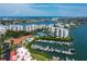 Aerial view of waterfront property featuring condo buildings, a marina with boats, and stunning ocean views on a clear, sunny day at 7907 Sailboat Key S Blvd # 108, South Pasadena, FL 33707