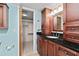 Bathroom featuring a granite countertop, wooden cabinets, and walk-in closet for extra storage at 7907 Sailboat Key S Blvd # 108, South Pasadena, FL 33707