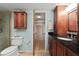 Bathroom with a walk-in closet, wooden cabinets, granite countertop, and modern fixtures at 7907 Sailboat Key S Blvd # 108, South Pasadena, FL 33707