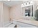 Bathroom featuring a shower-tub combo, a vanity, and light pink tile and wallpaper at 7907 Sailboat Key S Blvd # 108, South Pasadena, FL 33707