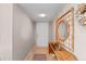 Entryway with tile flooring, rattan mirror and console table and a white door at 7907 Sailboat Key S Blvd # 108, South Pasadena, FL 33707