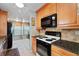 Well-equipped kitchen with granite countertops, wood cabinets, and modern appliances for cooking at 7907 Sailboat Key S Blvd # 108, South Pasadena, FL 33707