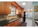 Well-equipped kitchen with wood cabinets, granite countertops, and modern appliances for cooking at 7907 Sailboat Key S Blvd # 108, South Pasadena, FL 33707