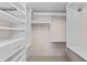 Bright walk-in closet with custom shelving, hanging rods, and carpet for organized storage at 7907 Sailboat Key S Blvd # 108, South Pasadena, FL 33707