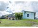 View of backyard featuring a screened-in enclosure and lush lawn at 909 Silver Palm Way, Apollo Beach, FL 33572