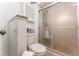 Compact bathroom featuring a toilet, shower with frosted glass, and convenient storage, maximizing space efficiency at 909 Silver Palm Way, Apollo Beach, FL 33572